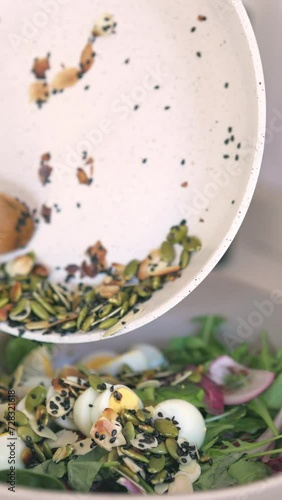 Preparing salad with seeds. Vertical video