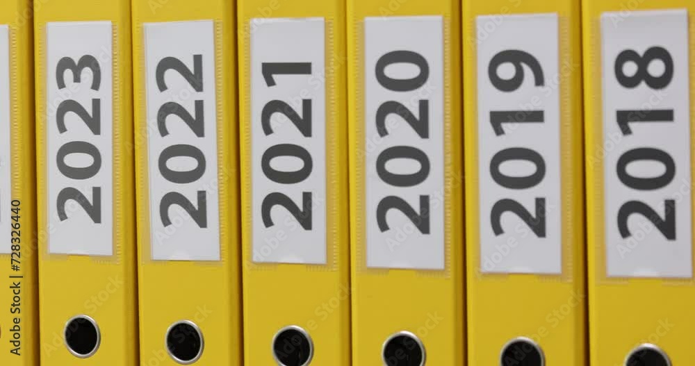 Stack of yellow office folders with new year concept on shelf Stack of yellow office folders with new year concept on shelf