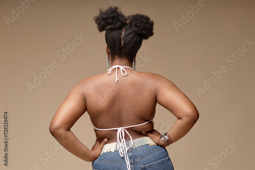 Woman standing with hands on hip against brown background photo