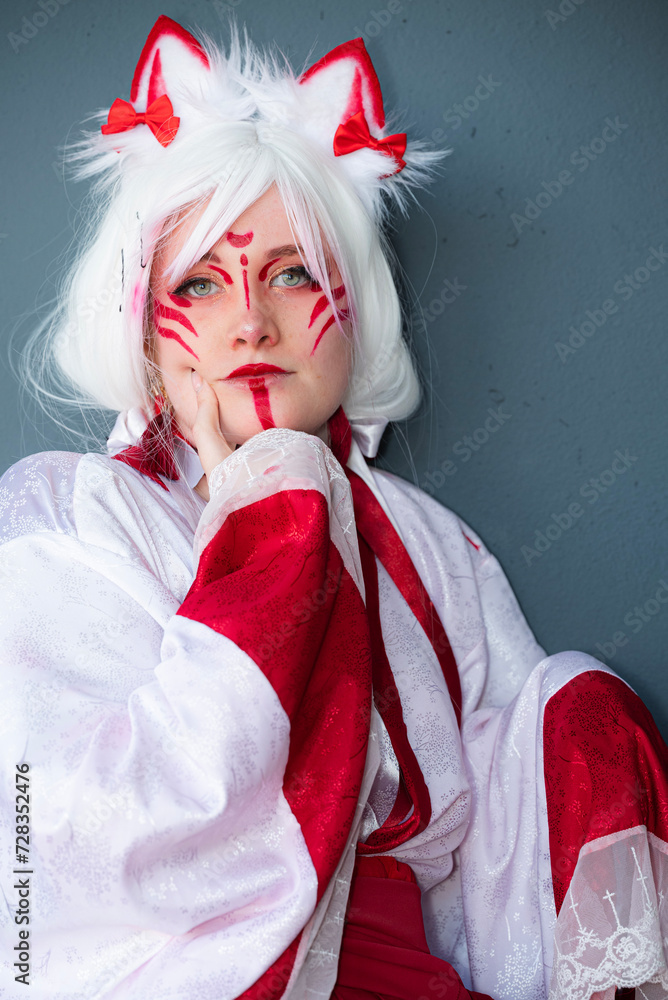 Cosplayer dressed in a Japanese white and red cat priestess costume