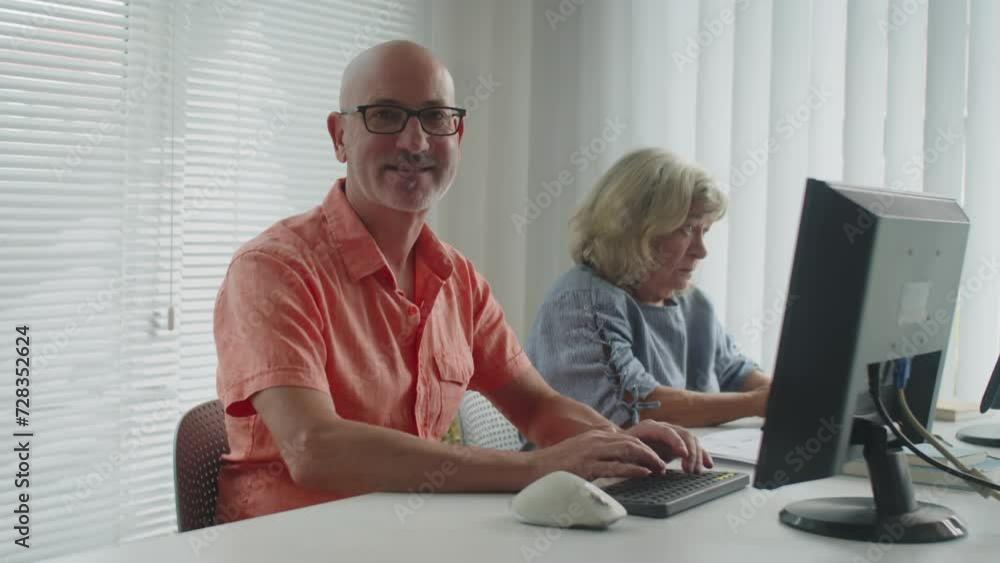 Portrait of adult man attending class for advanced computer students and smiling at camera Portrait of adult man attending class for advanced computer students and smiling at camera