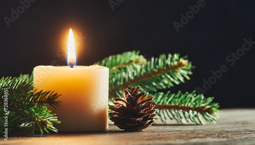 Close up of candle burning on table and fir branch over black background  cinematic light