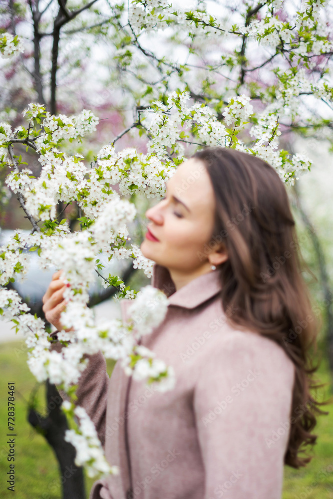 Healthy happy woman on spring outdoors. Smiling young woman on the spring garden enjoy blooming flowers of tree. Enjoy Nature. No allergy. Healthy happy woman on spring outdoors. Smiling young woman on the spring garden enjoy blooming flowers of tree. Enjoy Nature. No allergy.