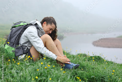Canvas Print Hiker suffering ankle ache after strumbling in nature