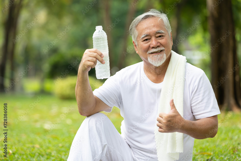 portrait senior man holding bottle of water and thumbs up pose in the park portrait senior man holding bottle of water and thumbs up pose in the park