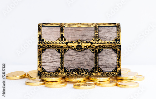 Wooden treasure chest on many golden coin on white background