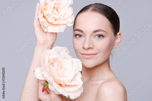Beautiful model with flower. Perfect woman face makeup close up. Lipstick. Beautiful nails. Nice smile. Perfect skin