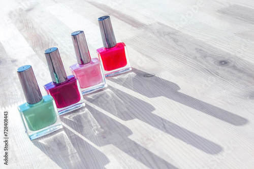 Group of bright nail polishes isolated on a wooden table photo