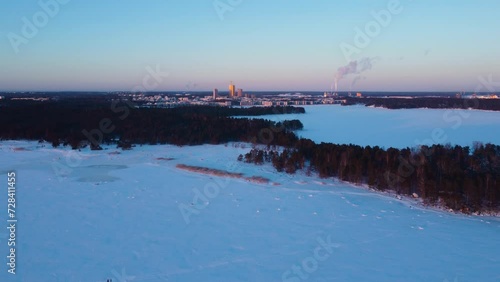 Aerial view over the sea, toward the cityscape of Helsinki, winter evening in Finland photo