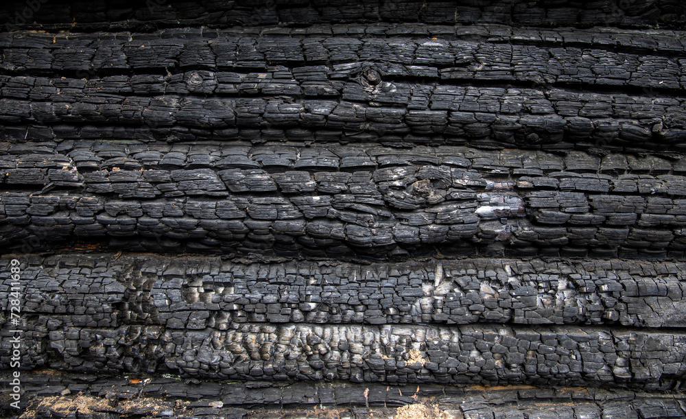 Charred wooden logs of a barn, bathhouse, house after a fire. Charred wooden logs of a barn, bathhouse, house after a fire.