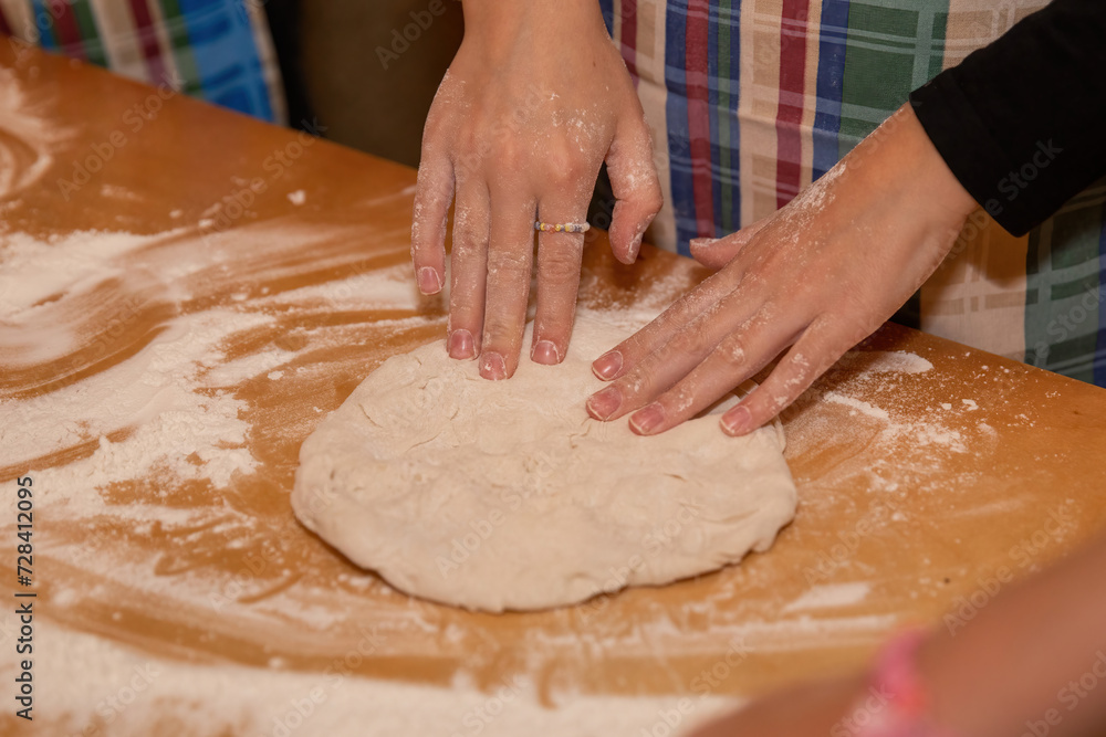 Making dough and pizza by a child.