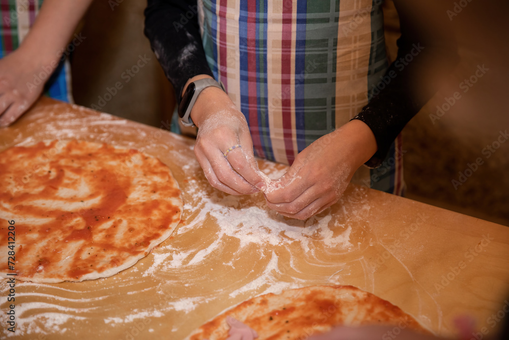 Making dough and pizza by a child.