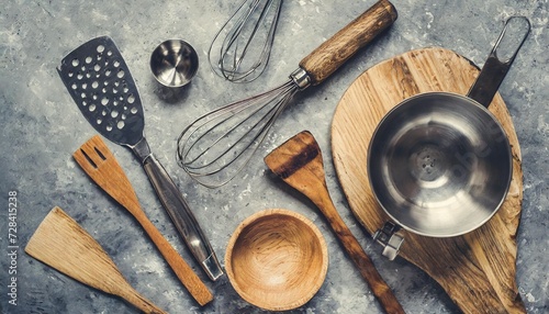 flat lay kitchen tools and utensils on a gray concrete background toned top view kitchenware is metal and wood photo