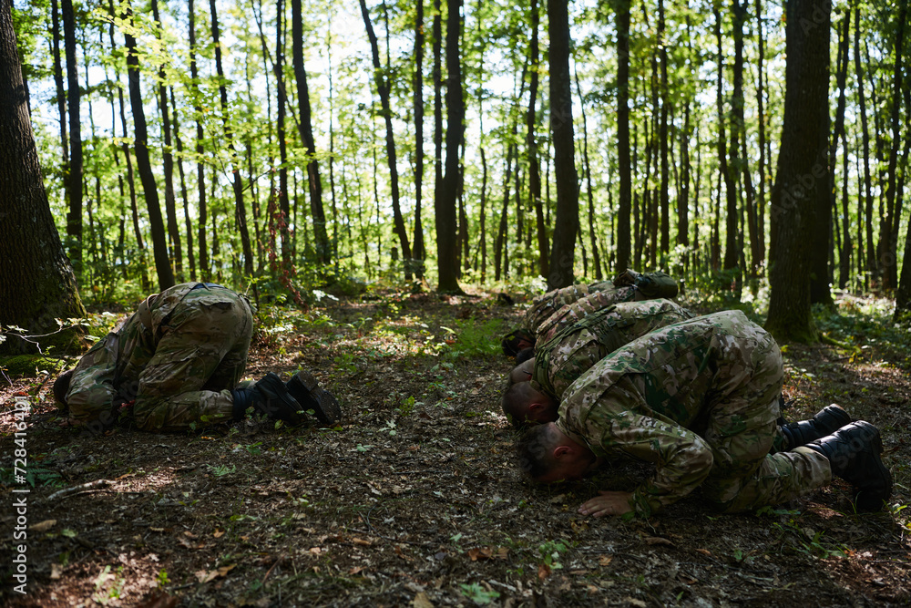 A dedicated group of soldiers engages in Islamic prayer amidst the challenging and perilous conditions of a military operation in dense forested areas A dedicated group of soldiers engages in Islamic prayer amidst the challenging and perilous conditions of a military operation in dense forested areas
