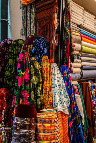 Traditional Turkish clothes in the bazaar, a vibrant display of cultural textiles, patterns, and garments, creating a marketplace of diverse textures and fashion. © MehmetAnl