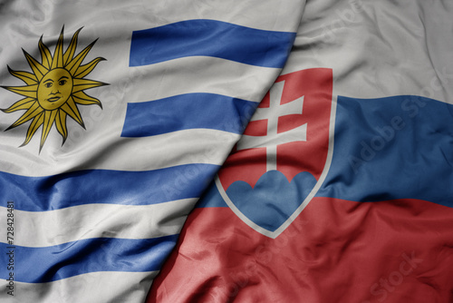 Canvas Print big waving national colorful flag of slovakia and national flag of uruguay