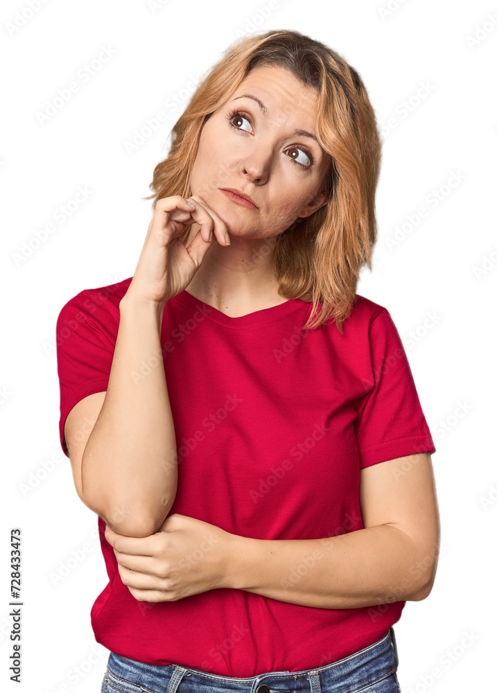 Blonde middle-aged Caucasian woman in studio thinking and looking up, being reflective, contemplating, having a fantasy. Blonde middle-aged Caucasian woman in studio thinking and looking up, being reflective, contemplating, having a fantasy.