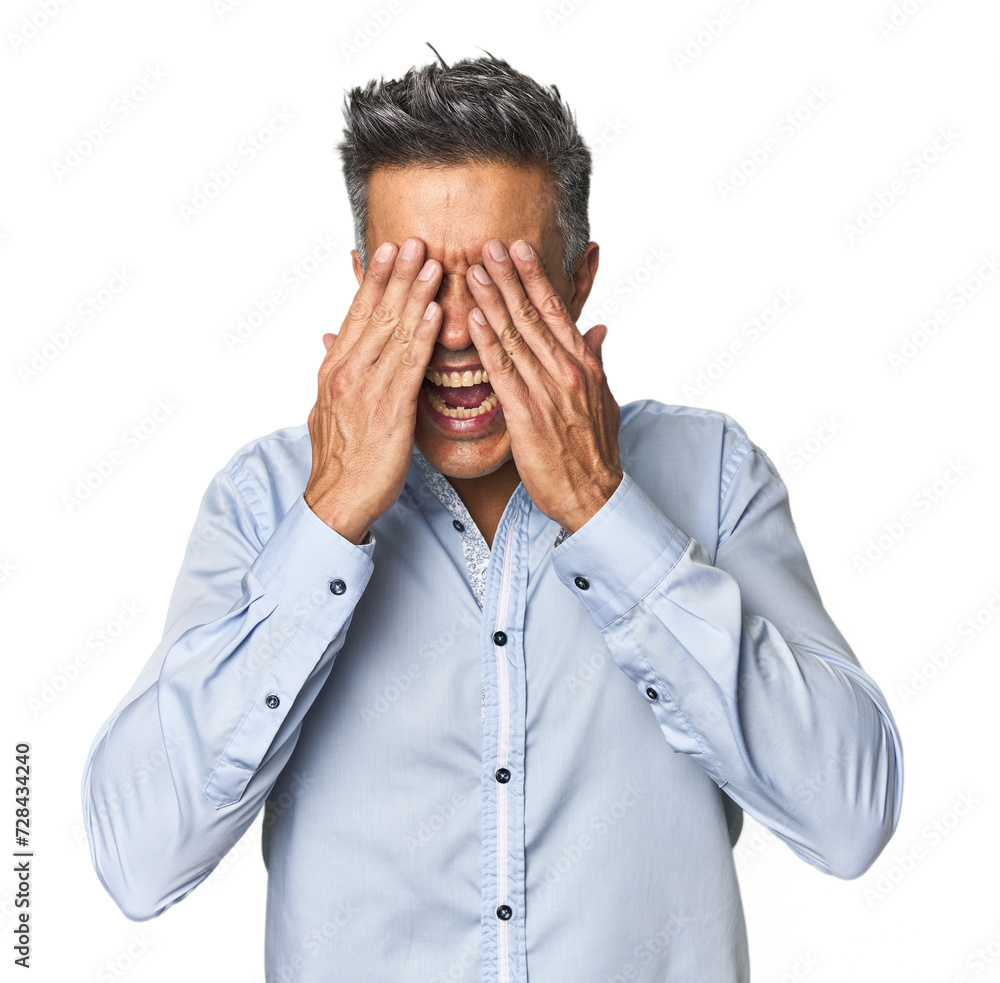 Middle-aged Latino man covers eyes with hands, smiles broadly waiting for a surprise. Middle-aged Latino man covers eyes with hands, smiles broadly waiting for a surprise.