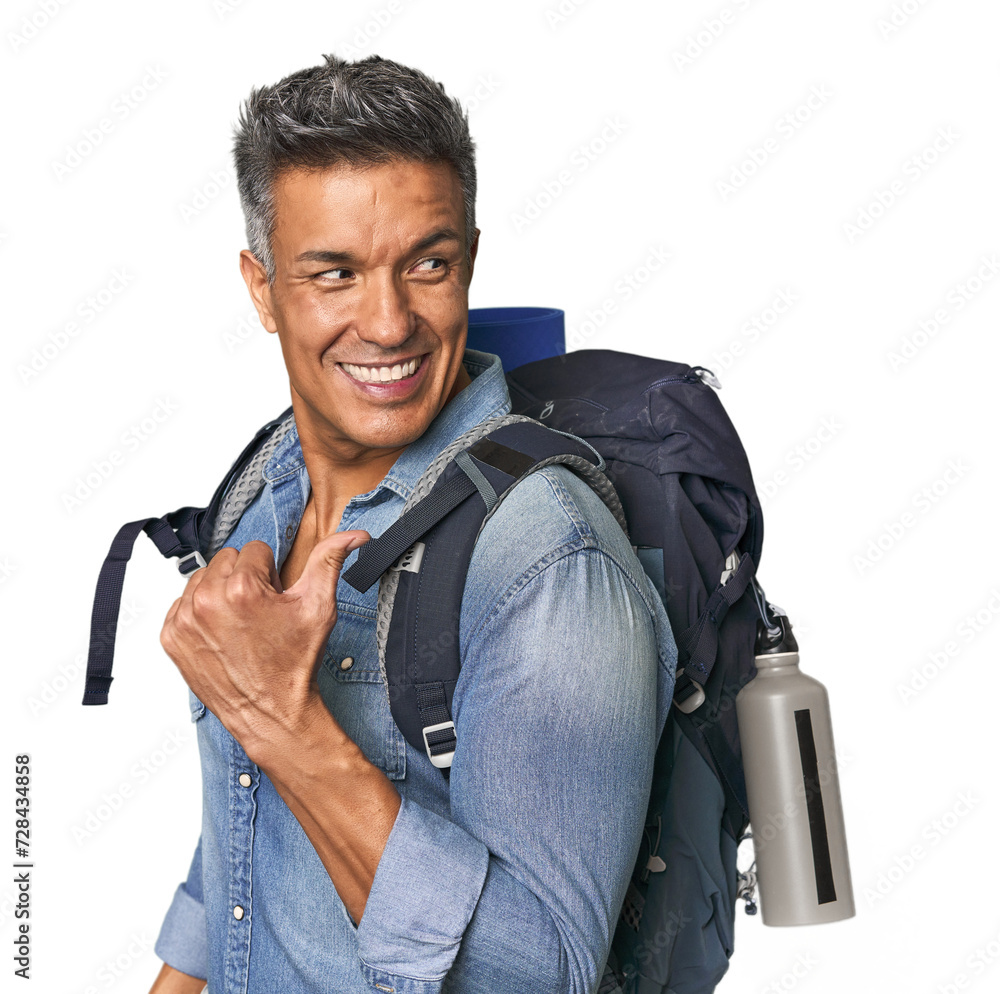 Hispanic hiker with backpack and flask points with thumb finger away, laughing and carefree. Hispanic hiker with backpack and flask points with thumb finger away, laughing and carefree.