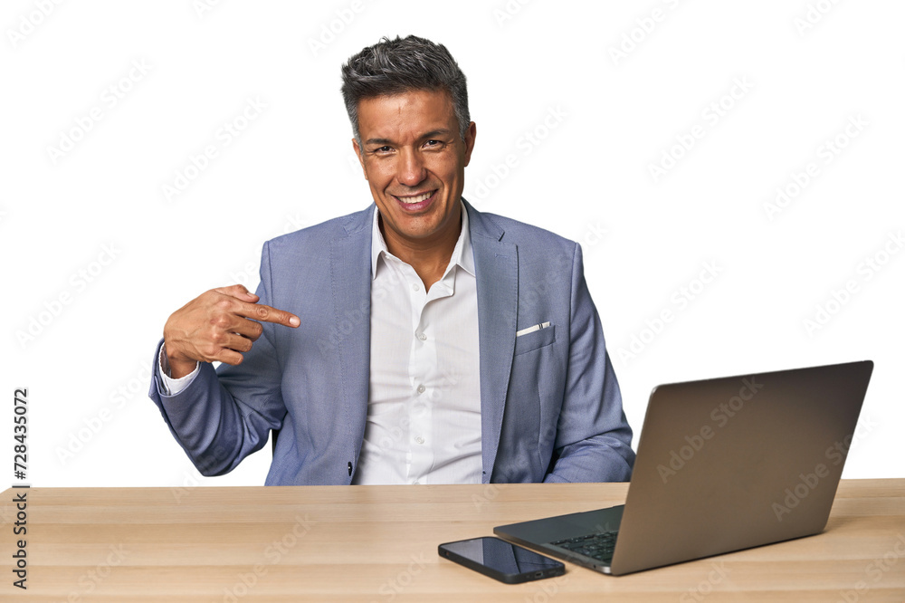 Elegant businessman at desk with laptop person pointing by hand to a shirt copy space, proud and confident Elegant businessman at desk with laptop person pointing by hand to a shirt copy space, proud and confident