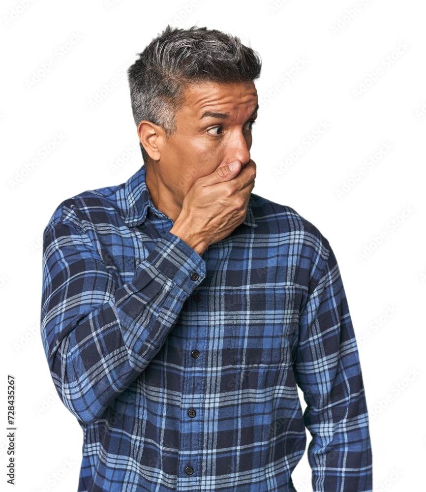 Middle-aged Latino man thoughtful looking to a copy space covering mouth with hand. Middle-aged Latino man thoughtful looking to a copy space covering mouth with hand.