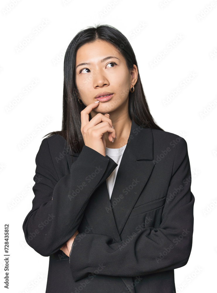 Young Chinese woman in business suit relaxed thinking about something looking at a copy space. Young Chinese woman in business suit relaxed thinking about something looking at a copy space.