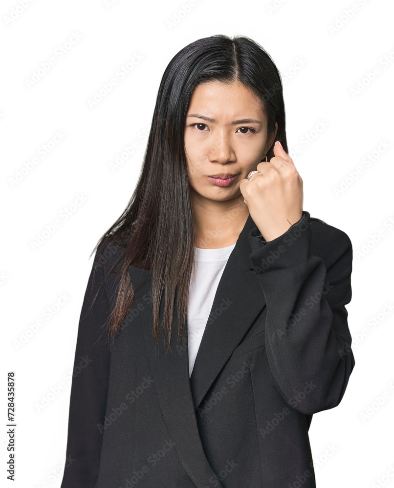 Young Chinese woman in business suit showing fist to camera, aggressive facial expression. Young Chinese woman in business suit showing fist to camera, aggressive facial expression.