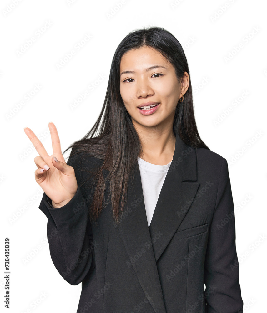 Young Chinese woman in business suit joyful and carefree showing a peace symbol with fingers. Young Chinese woman in business suit joyful and carefree showing a peace symbol with fingers.