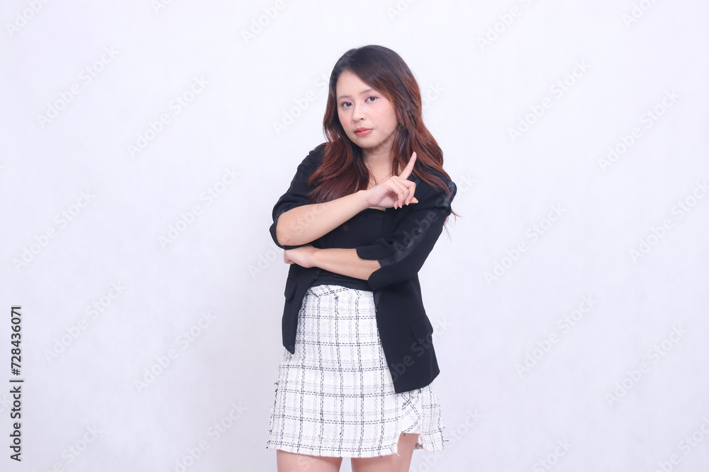 beautiful Asian Indonesian girl 20s formal office serious face arms crossed pointing to left above isolated white background beautiful Asian Indonesian girl 20s formal office serious face arms crossed pointing to left above isolated white background