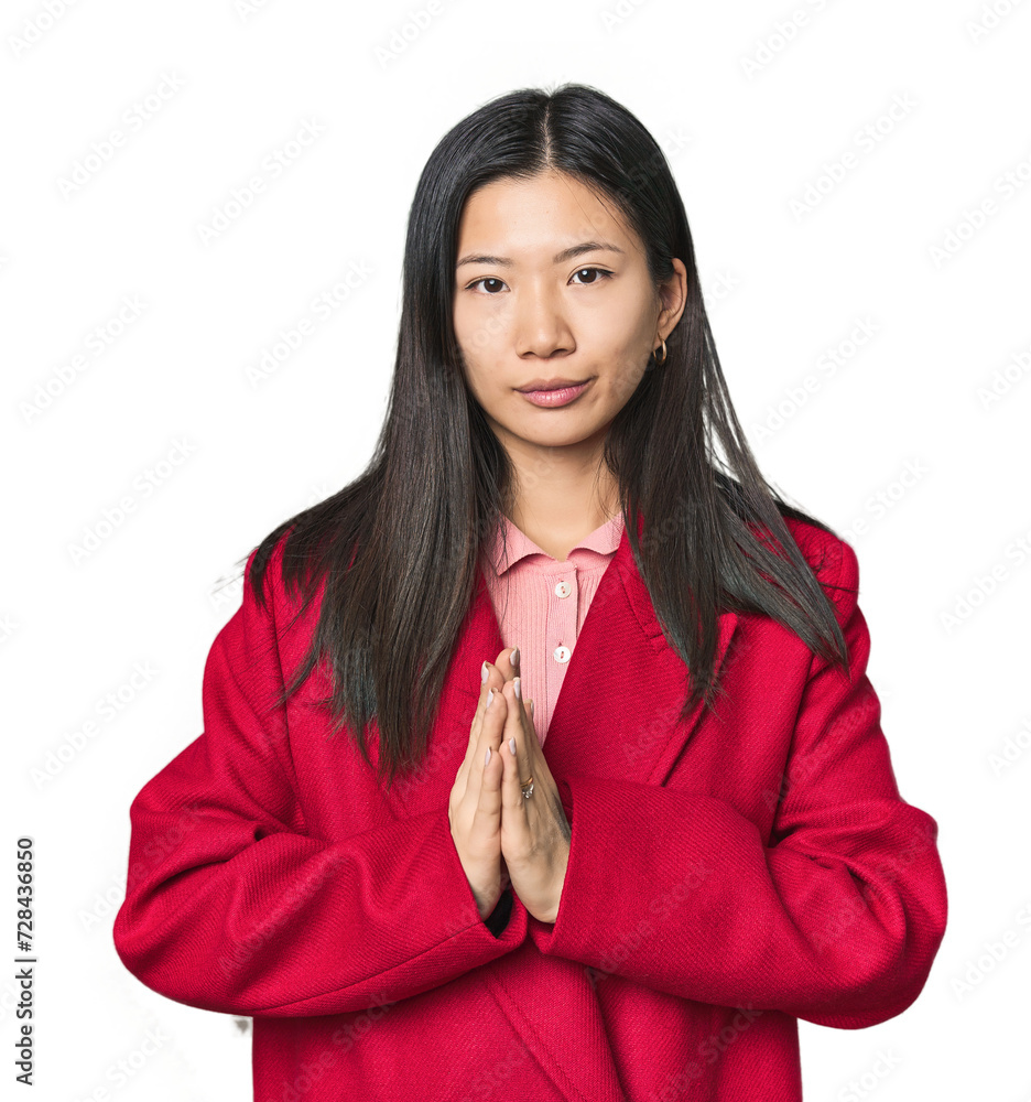 Young Chinese woman in studio setting praying, showing devotion, religious person looking for divine inspiration. Young Chinese woman in studio setting praying, showing devotion, religious person looking for divine inspiration.