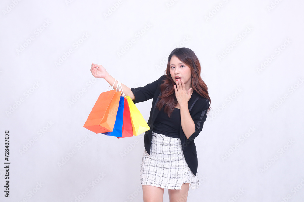 beautiful female customer asian 20s formal office elegant surprised tilted get bonus tote shopping goods paper bag colorful forearm isolated white background