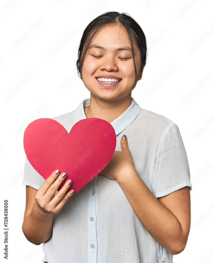 Young Chinese woman holding large paper heart in studio Young Chinese woman holding large paper heart in studio