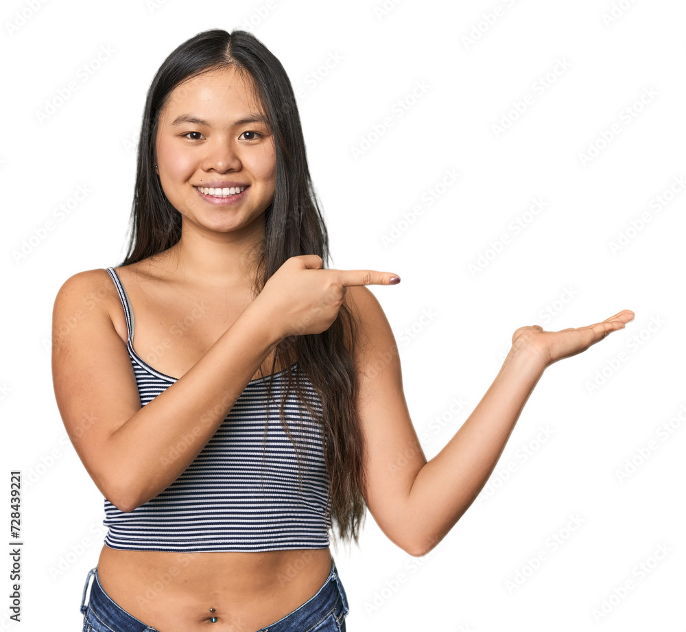 Young Chinese woman in gray top, studio excited holding a copy space on palm. Young Chinese woman in gray top, studio excited holding a copy space on palm.