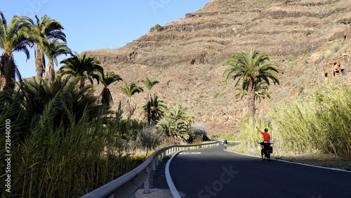 Tourist traveler on bicycle on vacation on mountain road in Canary Islands. Healthy lifestyle concept