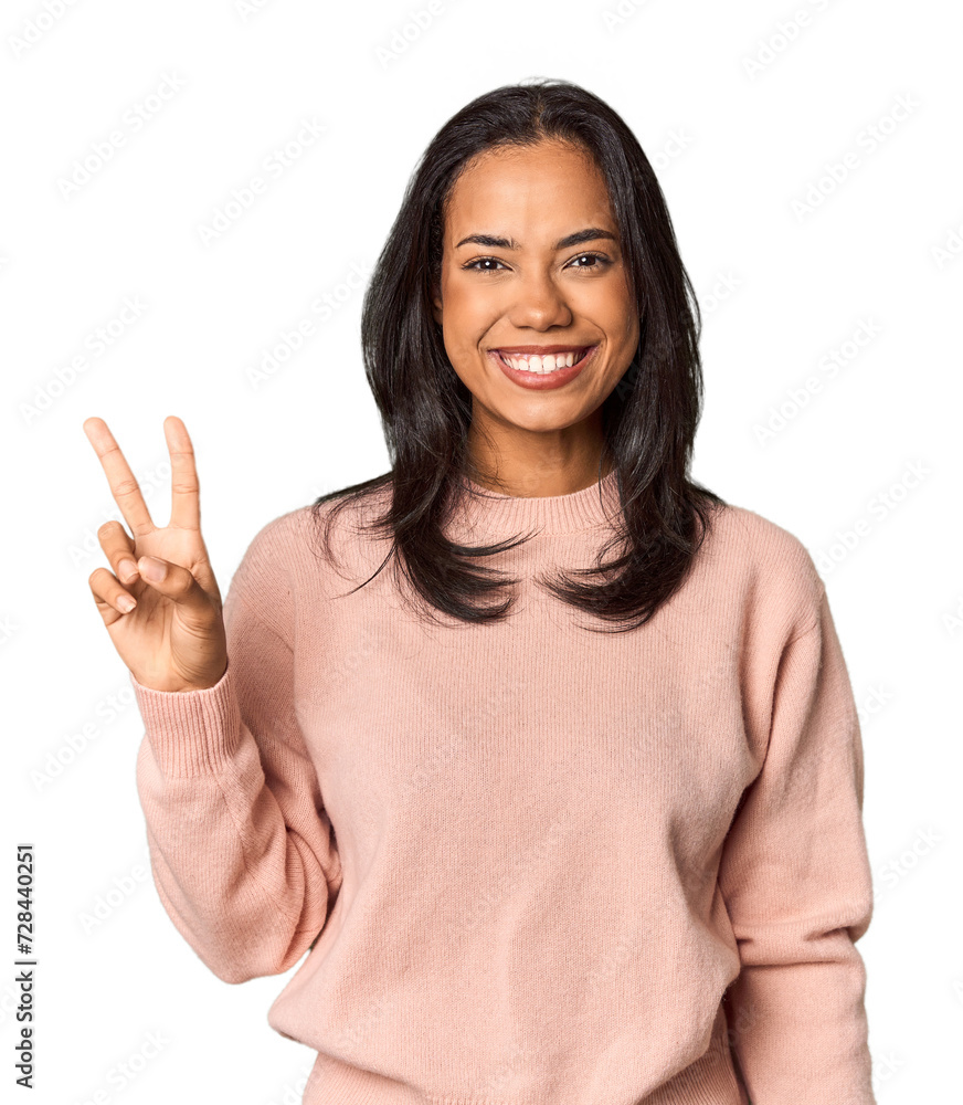 Young Filipina with long black hair in studio joyful and carefree showing a peace symbol with fingers. Young Filipina with long black hair in studio joyful and carefree showing a peace symbol with fingers.