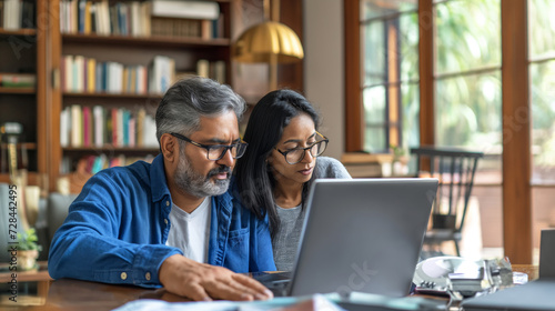 Middle age Indian couple managing finances, paying bills online at home