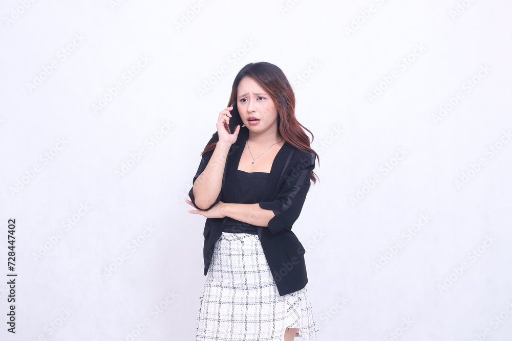 Beautiful Indonesian girl in her 20s, formal office, shocked while on the phone with her black cellphone gadget and carrying a tablet for promotions isolated on a white background Beautiful Indonesian girl in her 20s, formal office, shocked while on the phone with her black cellphone gadget and carrying a tablet for promotions isolated on a white background