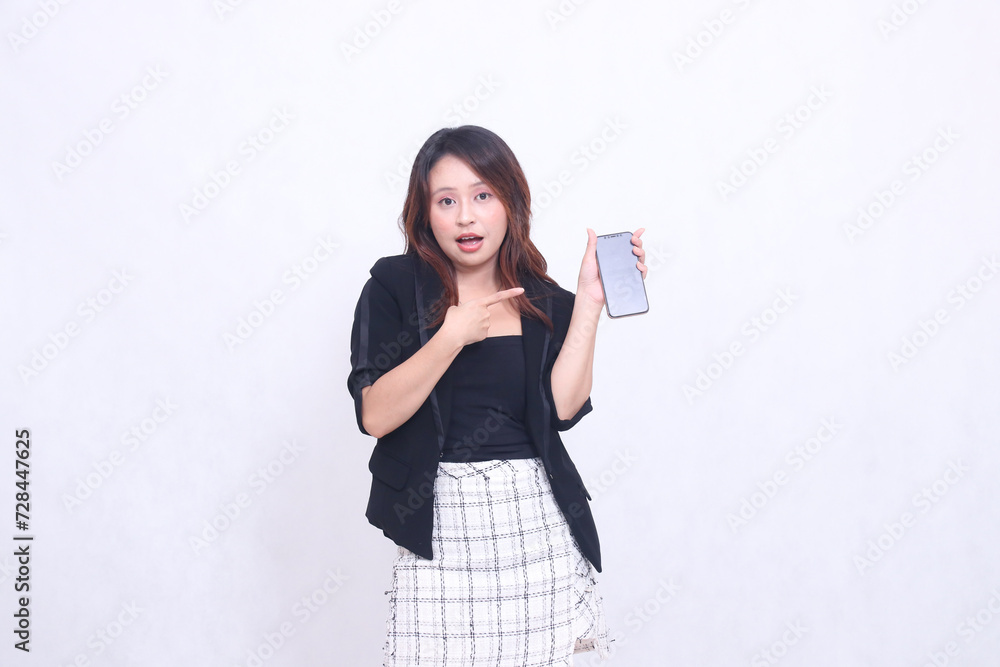 beautiful Indonesian office woman 20s expression of surprise on promotion of cellphone gadget screen for promo while pointing at it underneath isolated white background beautiful Indonesian office woman 20s expression of surprise on promotion of cellphone gadget screen for promo while pointing at it underneath isolated white background