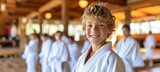 Smiling european boy engaged in judo or karate training lesson with space for text placement