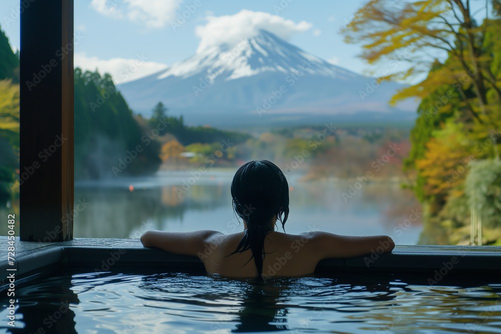 Rearview of woman enjoy Onsen in the morning and seeing Fuji mountain view from luxury hotel room Rearview of woman enjoy Onsen in the morning and seeing Fuji mountain view from luxury hotel room