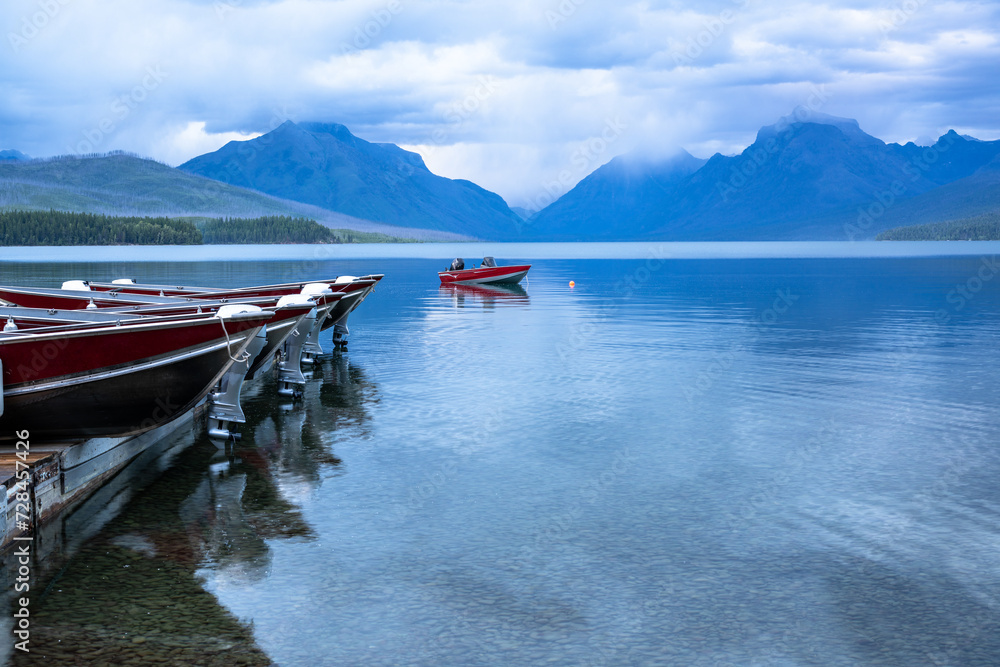 One boat left in the water while the rest are dry on the dock for the night, Apgar Village, Lake McDonald, Glacier National Park, Montana
