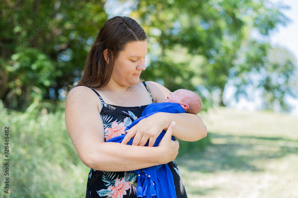 Mother holding week old baby boy in embrace outside Mother holding week old baby boy in embrace outside
