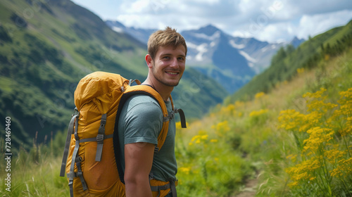 A young cheerful male traveler carries a backpack with things, uses a phone, a smartphone. A tourist leads an active healthy lifestyle, uses mobile Internet while hiking