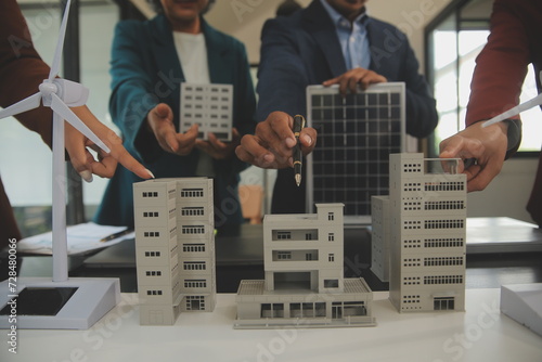 Close-up at tablet, Engineers pointing at tablet with their hands. To jointly design the use of renewable energy with wind and solar energy. Concept of using renewable energy.