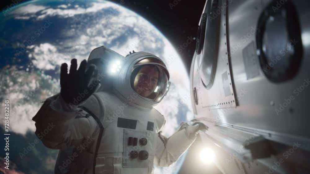 Portrait of an Astronaut Floating Outside a Spaceship with Planet Earth in the Background. Male Waving to the Camera. Professional Spaceman Posing in His Space Suit, Smiling Portrait of an Astronaut Floating Outside a Spaceship with Planet Earth in the Background. Male Waving to the Camera. Professional Spaceman Posing in His Space Suit, Smiling