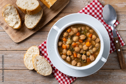 Chickpeas soup with vegetables in bowl on wooden table