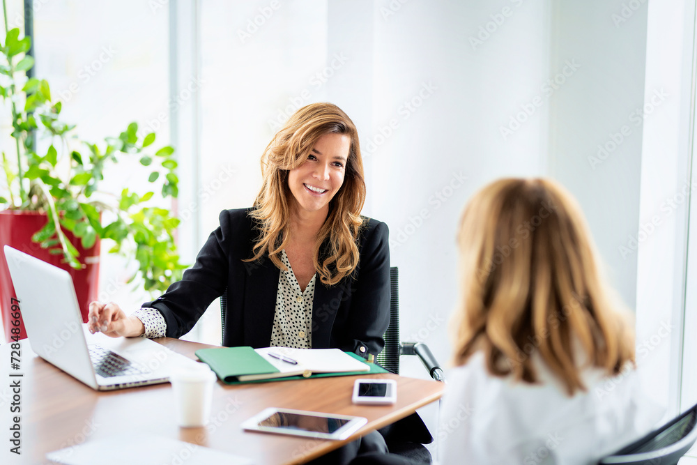 Group of business people sitting at desk and talking about new project Group of business people sitting at desk and talking about new project
