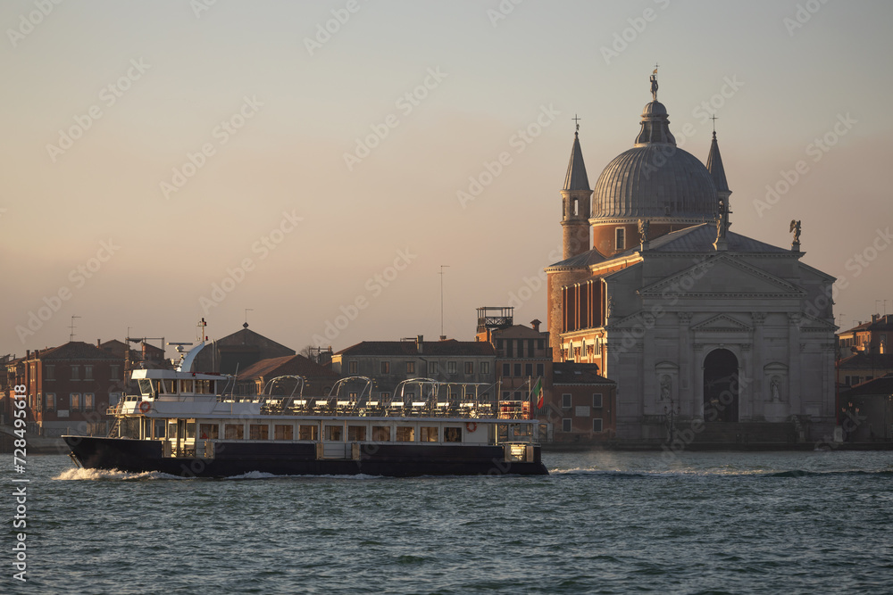 Touristic Discovery Boat Passing in Empty in front of the Holly Redeemer Church - Chiesa del Santissimo Redentore in Venice at Sunrise