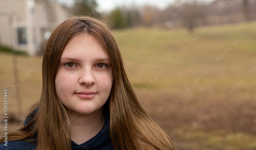 Teen girl looking at the camera outdoors on an overcast day with room for copy Teen girl looking at the camera outdoors on an overcast day with room for copy