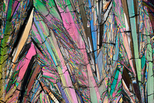 Close-up microscope image showcasing the intricate, colorful patterns of erythritol sugar crystals with varied hues and textures